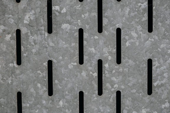 Verzinkte Metalloberfläche mit vertikalen schmalen Löchern