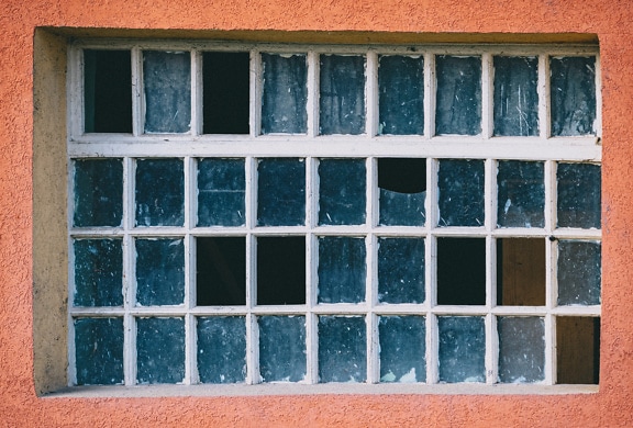 An old window with many small frames and broken glass