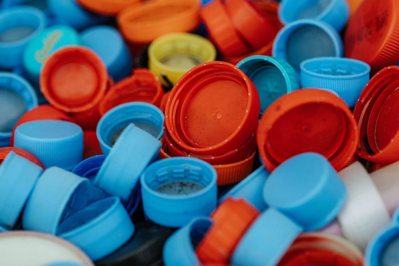 Veľa bordových a modrastých plastových uzáverov fliaš, ktoré sa dajú recyklovať