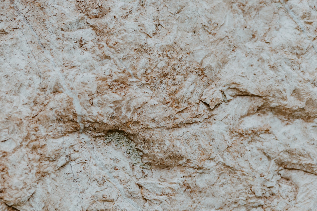 Textura close-up de uma superfície áspera de uma rocha bege natural