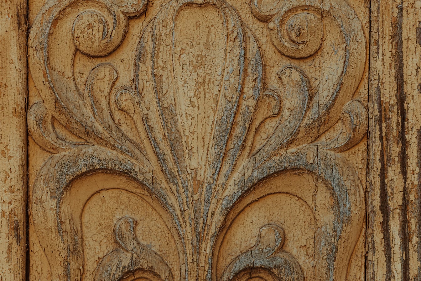 섬세한 대칭 디테일과 벗겨지는 오래된 황갈색 페인트가 있는 조각된 보드