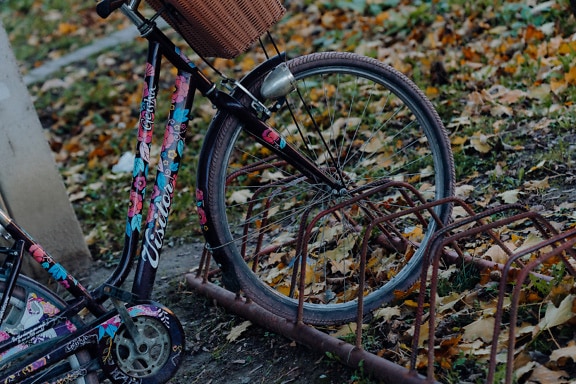 De kleurrijke fiets van vrouwen die in fietsenrek wordt geparkeerd
