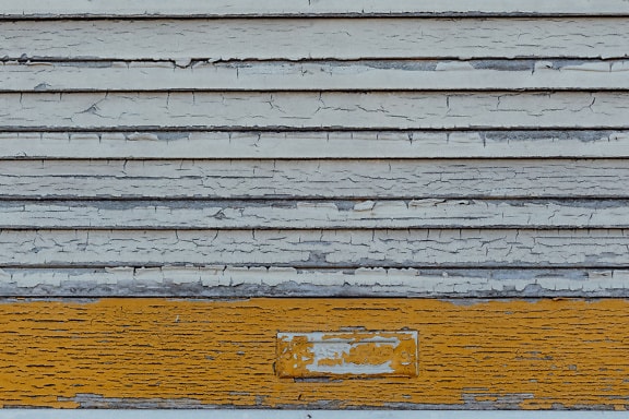Texture di vecchie tende in legno con vecchia vernice bianca e giallo arancio che si stacca