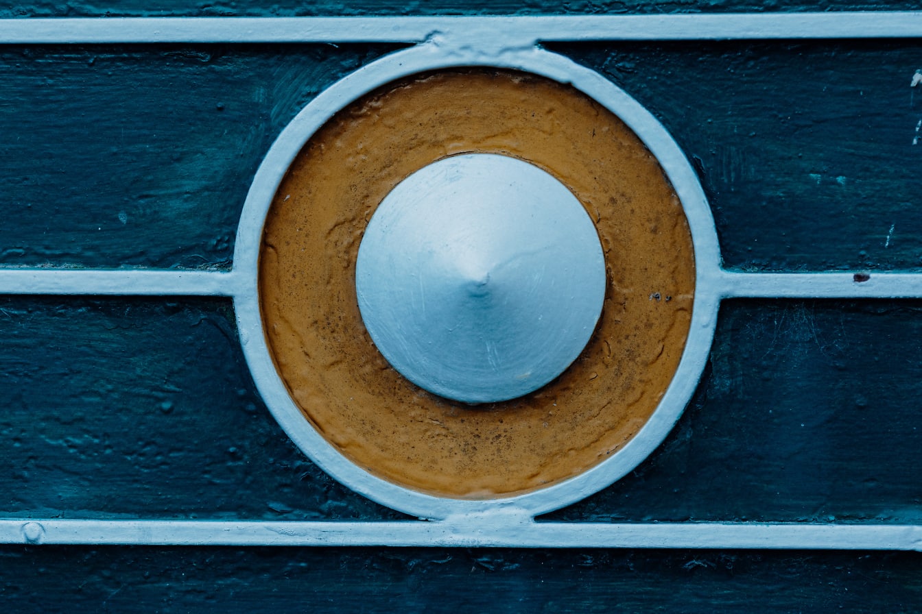 Ciemnoniebieska metalowa powierzchnia z niebieskawo-brązową okrągłą dekoracją pośrodku