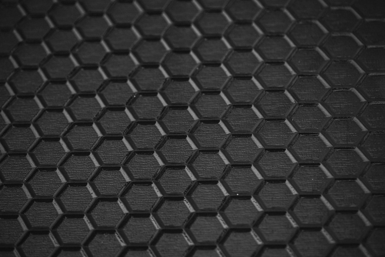 Tampilan close-up kaca hitam dengan tekstur sarang lebah di permukaan