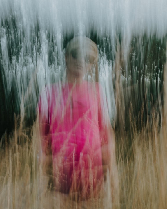 Portrait d’une femme en chemise rose avec un flou artistique intentionnel
