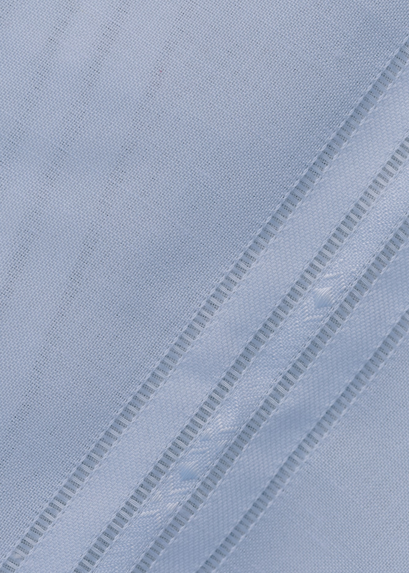 Çapraz çizgilere sahip beyaz pamuklu kumaşın yakın çekim dokusu