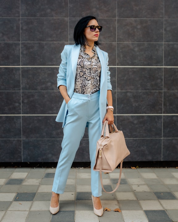 Portrait of a businesswoman posing in a modern blue suit and snake pattern shirt