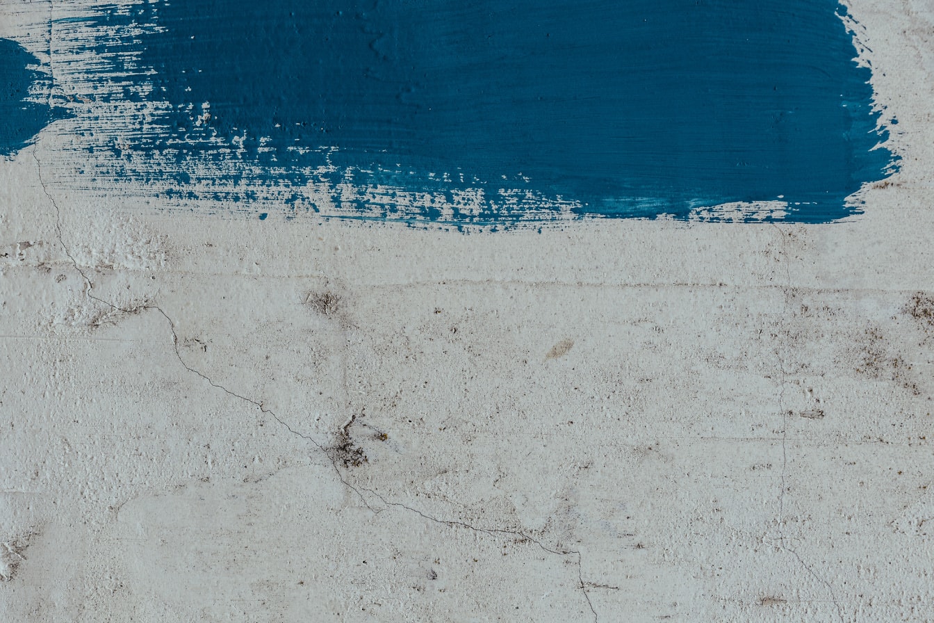 Textura da parede rachada branca suja com vestígios de uma tinta azul sobre ela