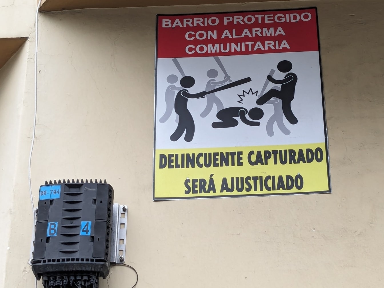 Varningsskylt mot brottslingar och banditer med en spanskspråkig inskription på väggen