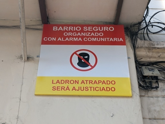 Ein Schild gegen Einbrecher und Diebe an der Wand mit Inschrift in spanischer Sprache