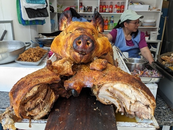 Large roasted pig a delicious delicates at street restaurant in Latin America