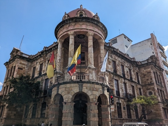 Municipal building in downtown of Cuenca city in Spanish colonial architectural style with flag of Ecuador on it