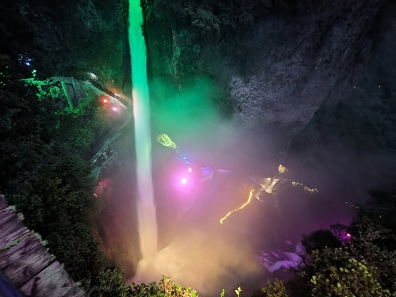 La Cascada del Diablo iluminada por luces de colores por la noche, una maravilla de la naturaleza y un atractivo turístico en el parque natural del Ecuador
