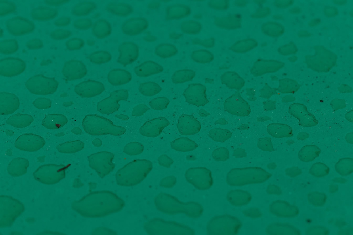 Textura unei picături de apă pe o suprafață verde