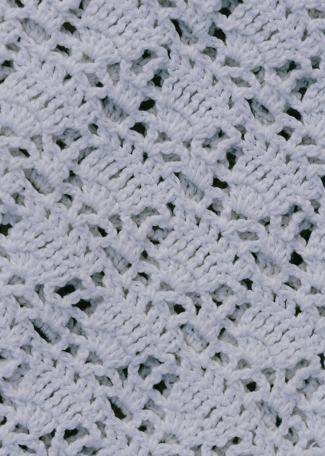 Nærbillede af et hvidt strikket stof med håndbroderi