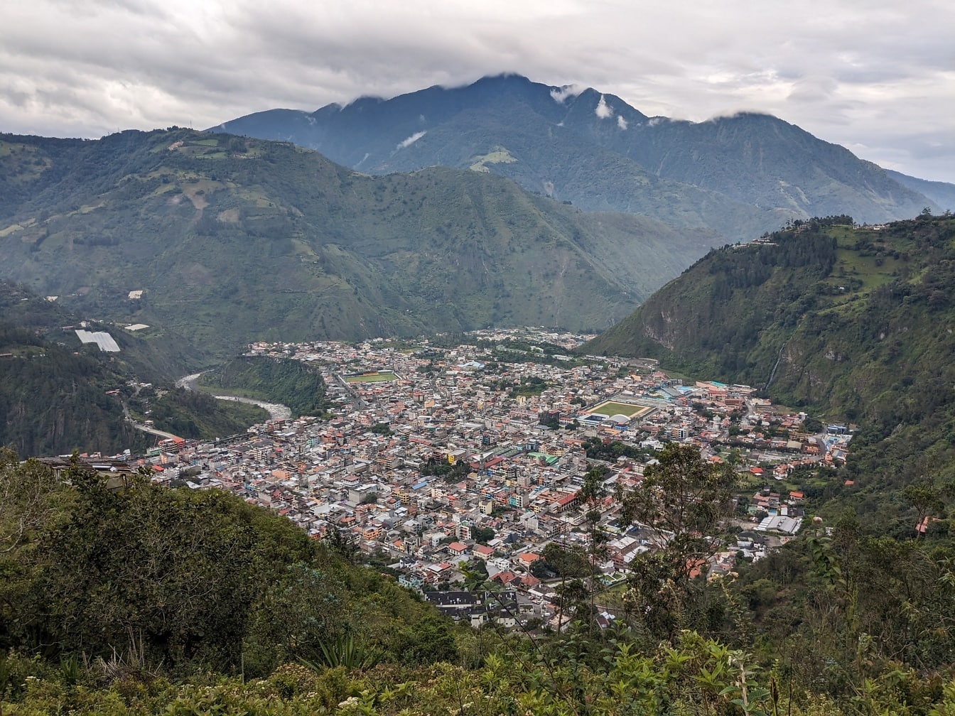 Panoráma Banos de Aqua Santa városára Ecuadorban egy völgyben, háttérben hegyekkel
