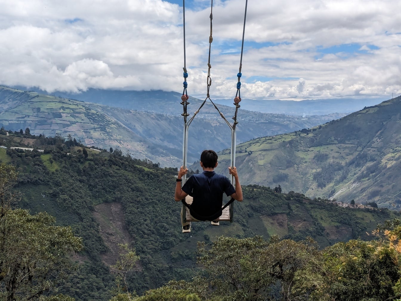 Bátor ember egy nagy hintán a völgy felett híres turisztikai attrakció Ecuadorban