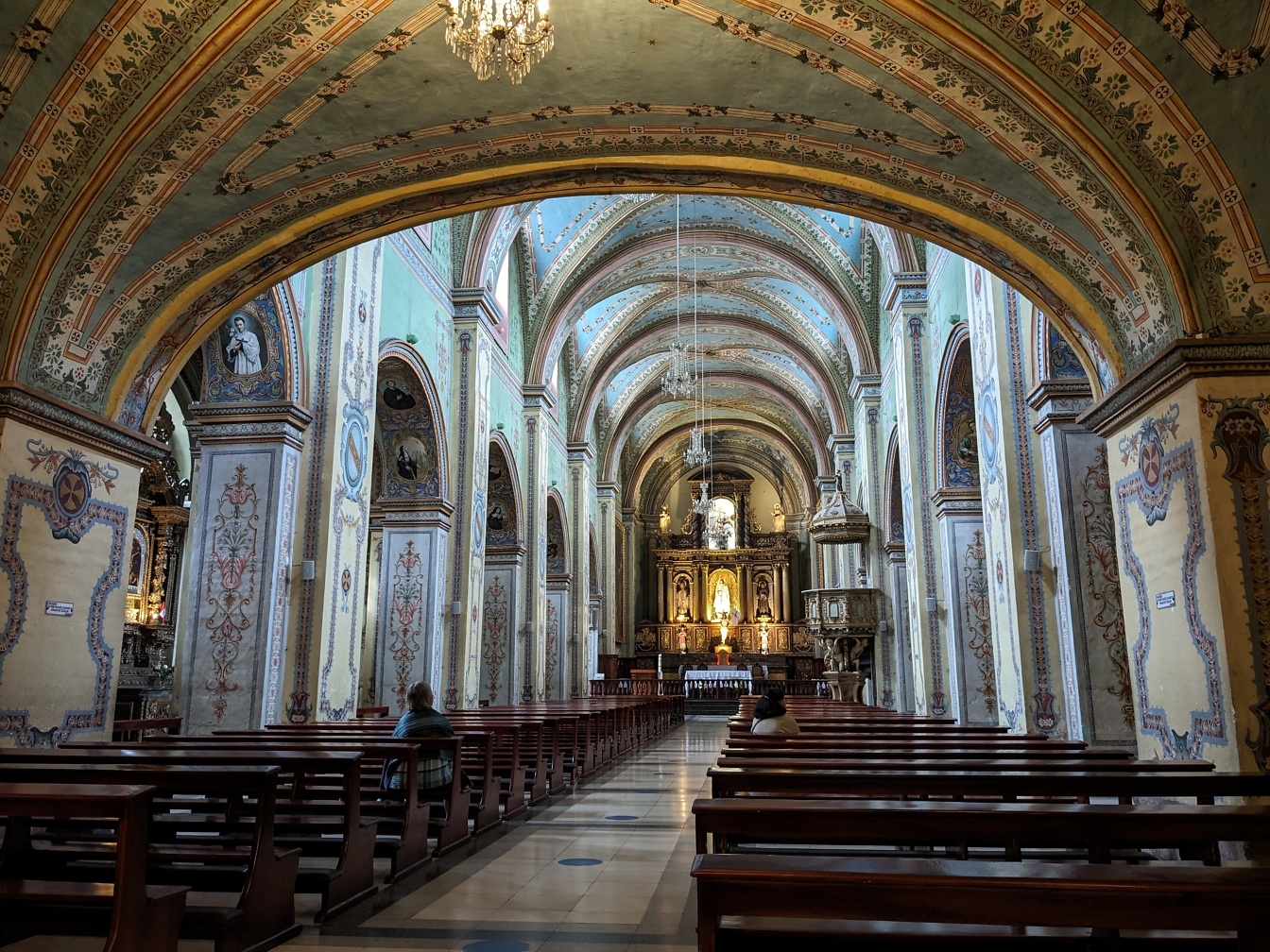 Interiör med många bänkar i det katolska templet för Augustinerorden och klostret San Agustin i staden Quito i Ecuador