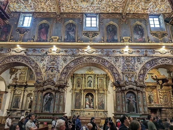 A pilgrimage tourist tour inside of the basilica and convent of San Francisco in Quito