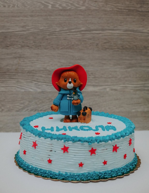 Fødselsdagskage med dekoration i form af en Paddington-bamse på toppen