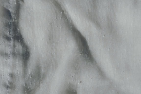 Trama di tessuto ovatta bianco puro sottile e semitrasparente con pieghe