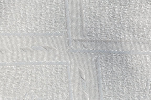 Close-up of a pure white cotton fabric with geometric pattern