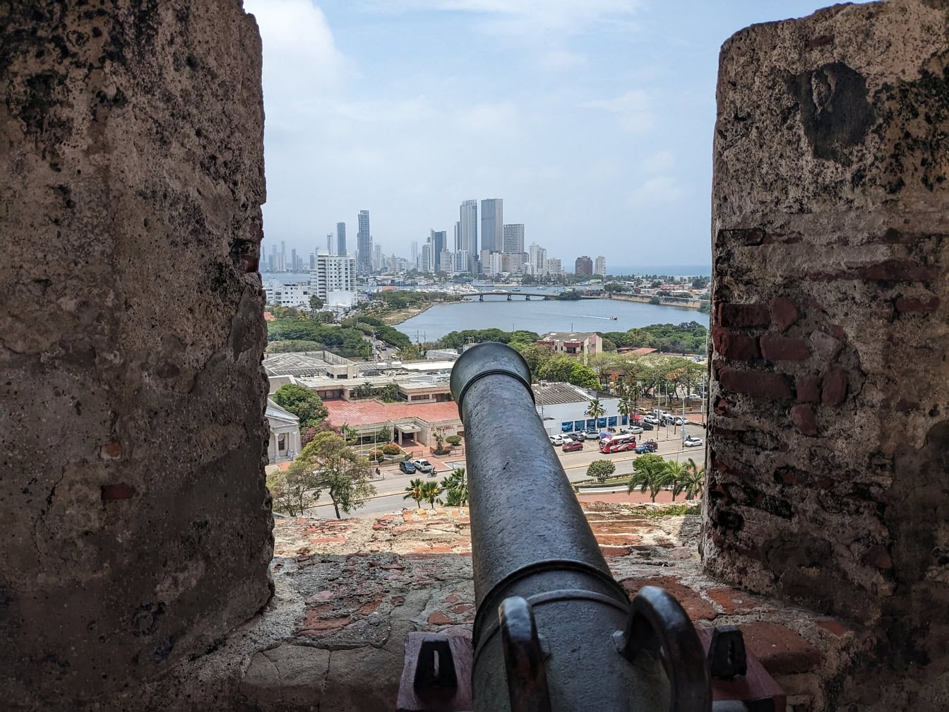 Kanon som tittar ut genom ett fönster från toppen av fästningen Castillo de San Felipe, en turistattraktion i staden Cartagena i Colombia