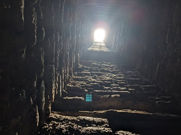 Светлина грее през върха на тунел в средновековна крепост