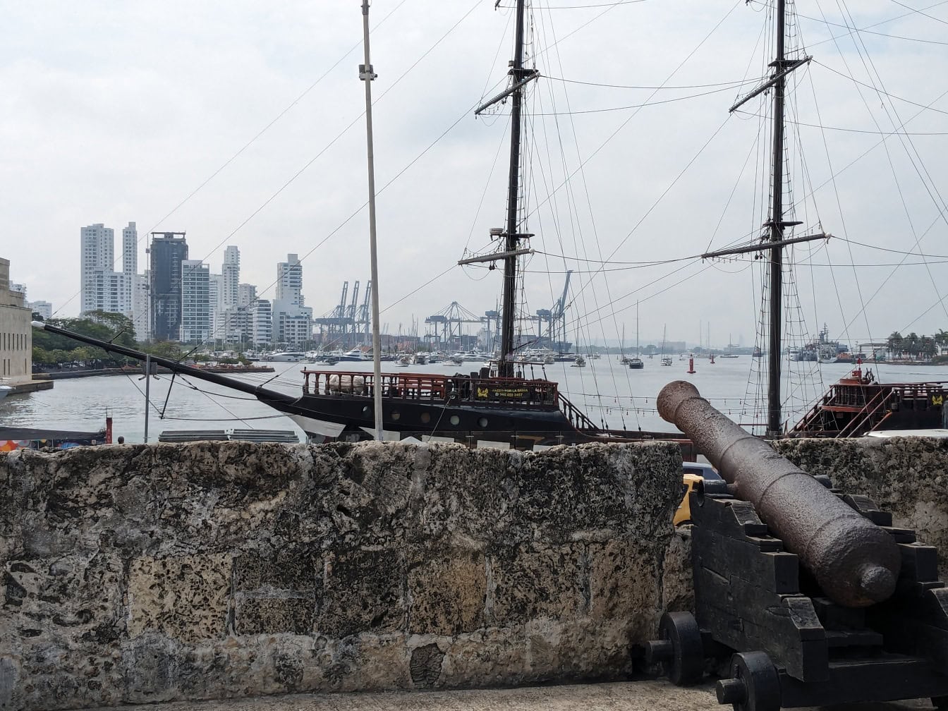 Середньовічна чавунна гармата біля стіни була спрямована на старий вітрильний корабель