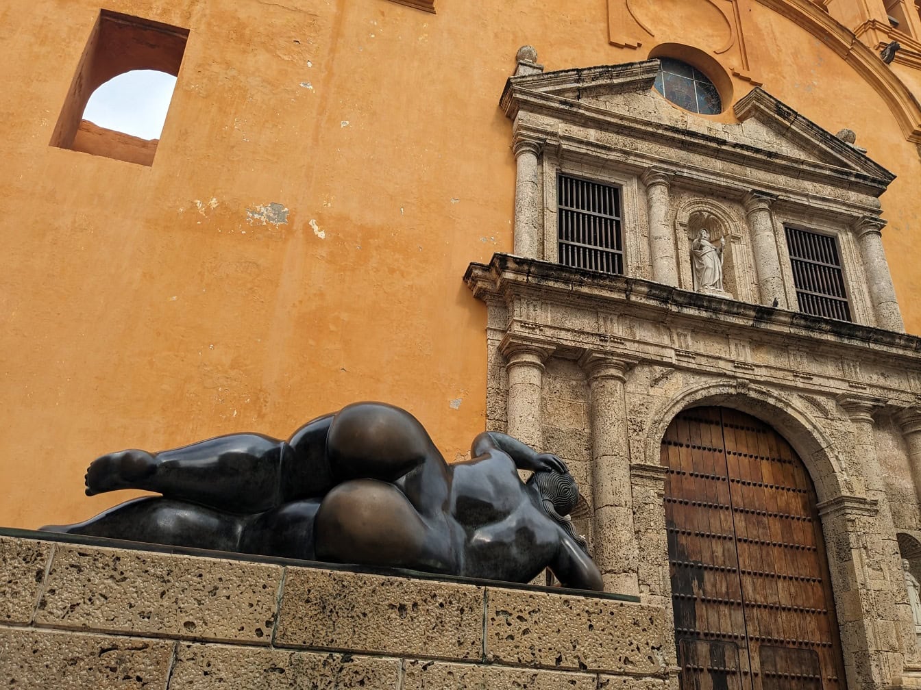 Statue av en kvinne som ligger på en vegg foran kirken Santo Domingo i Cartagena, Columbia