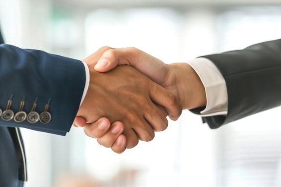 Närbild av affärsmäns handslag i ett kontor