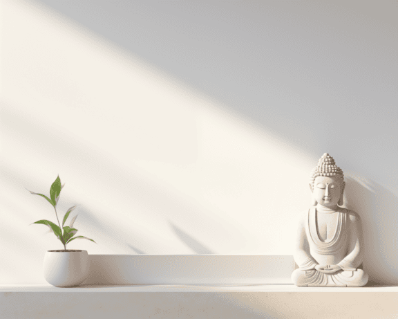 Wit beeldje van een mediterende Boedha in een lotusbloempositie op plank op witte muur onder zachte schaduw