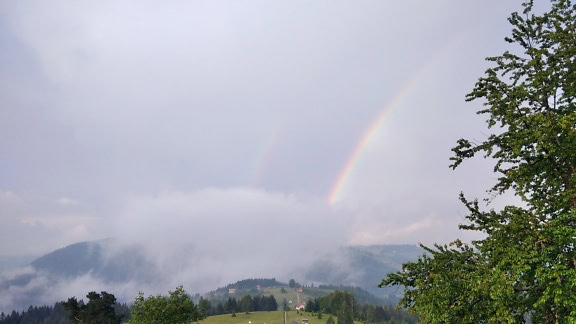 山谷上空白云中的彩虹
