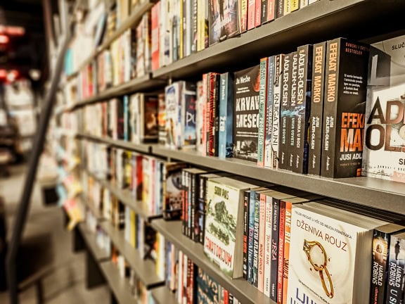 Police s různými knihami na prodej v knihkupectví