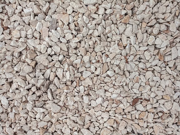 Textur av små gråvita granitstenar