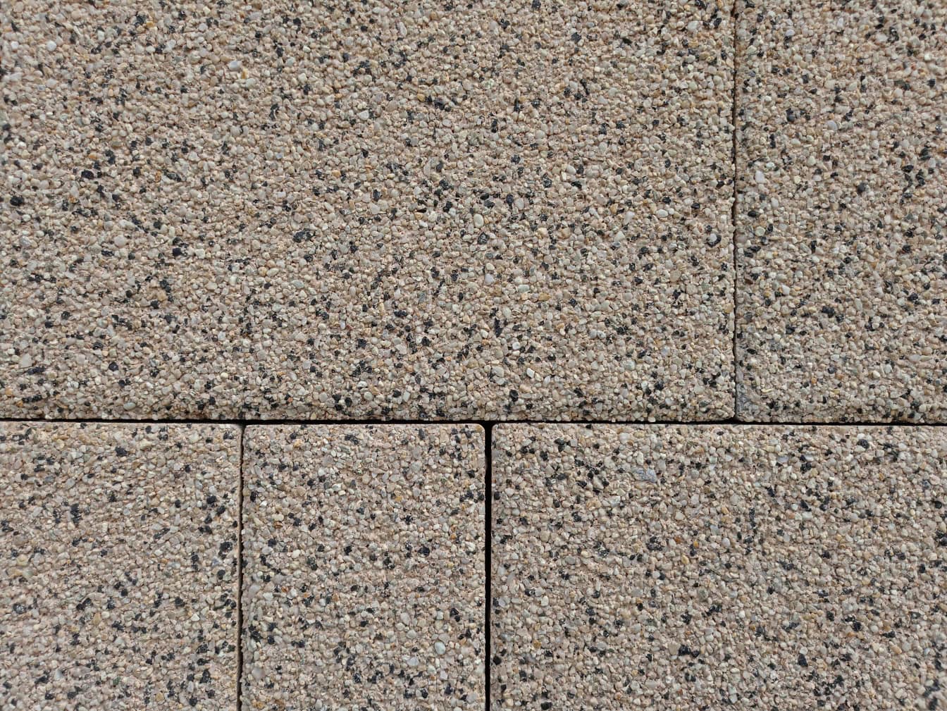 Lähikuva hyvin pienistä graniittikivistä valmistettujen kivilaattojen tekstuurista