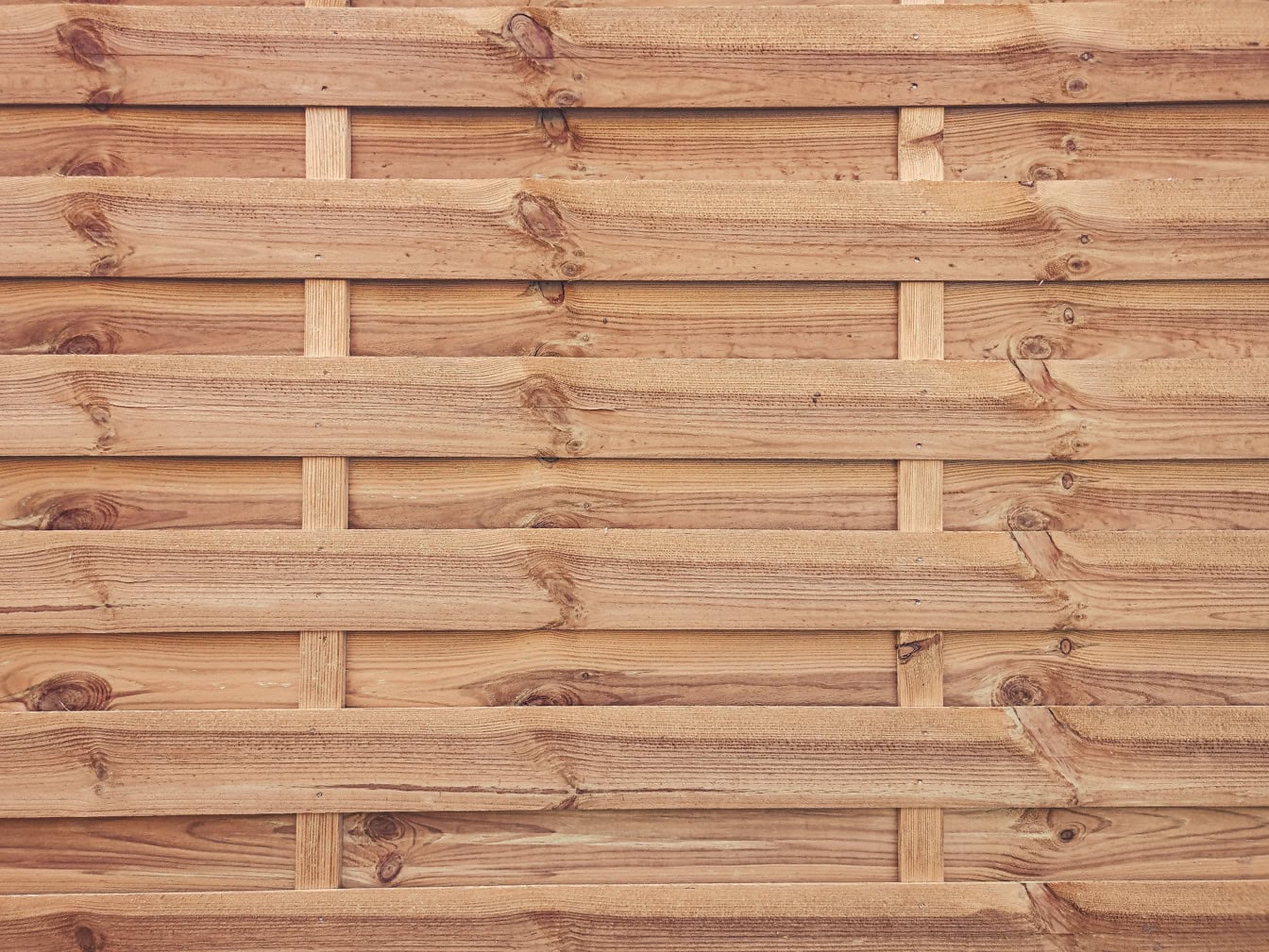 Textura de uma parede de madeira feita de tábuas finas de madeira com nós empilhados horizontalmente