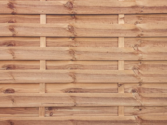 Texture d’un mur en bois fait de fines planches de bois avec des nœuds empilés horizontalement
