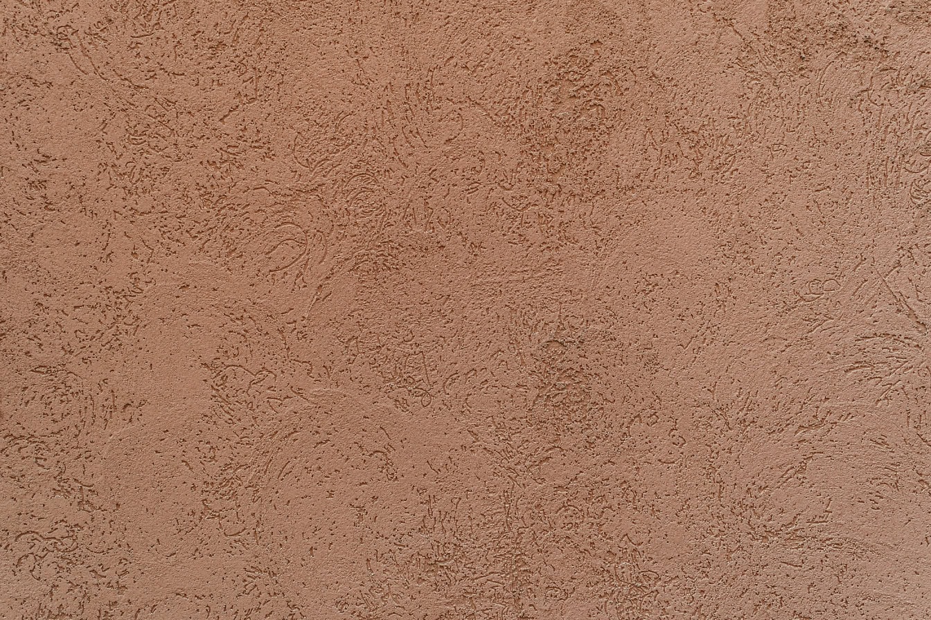 Textura de pared con relieve superficial y cemento de fachada en color marrón anaranjado
