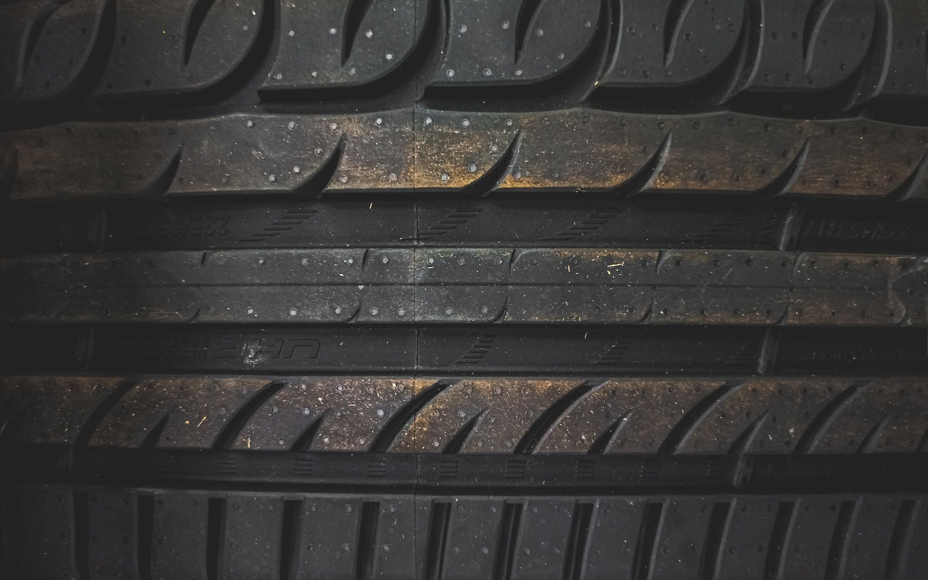 Texture of a brand new tire with horizontal lines made from a mixture of natural latex rubber and recycled rubber