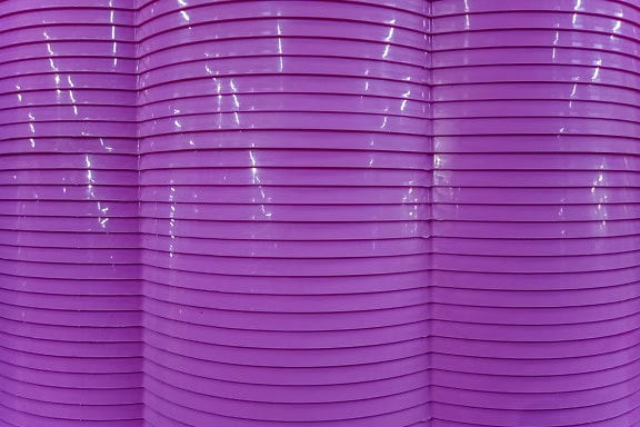 Texture of wavy darkish purple plastic with many horizontal lines