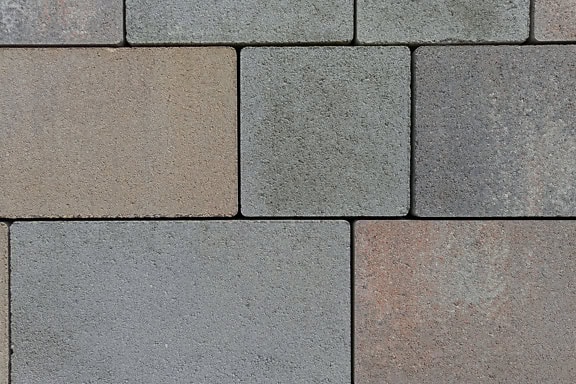 Tekstur af firkantede og rektangulære kunstige belægningsstenblokke lavet af malet beton