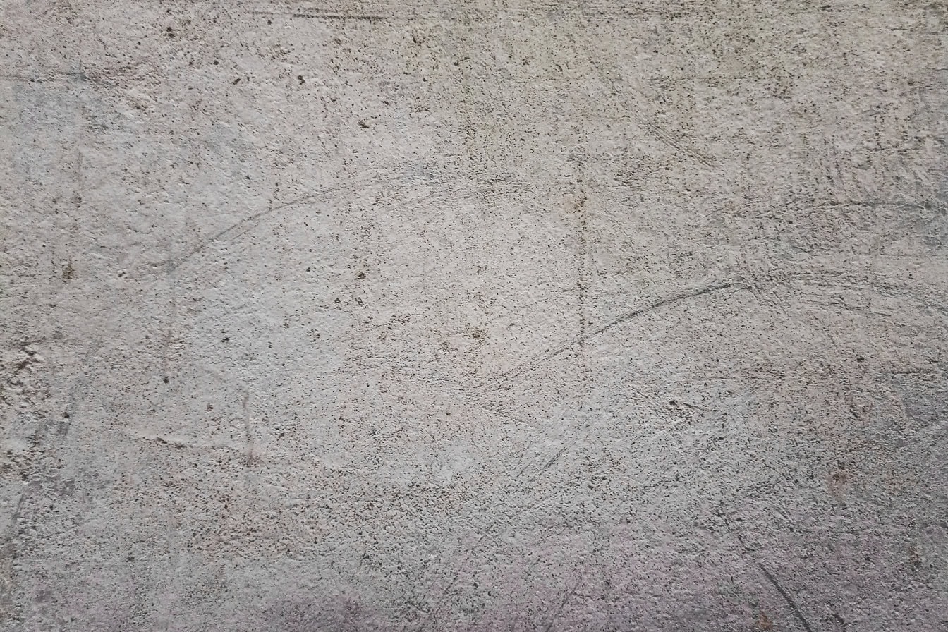 表面がざらざらした汚れた灰色がかったコンクリートの壁の質感