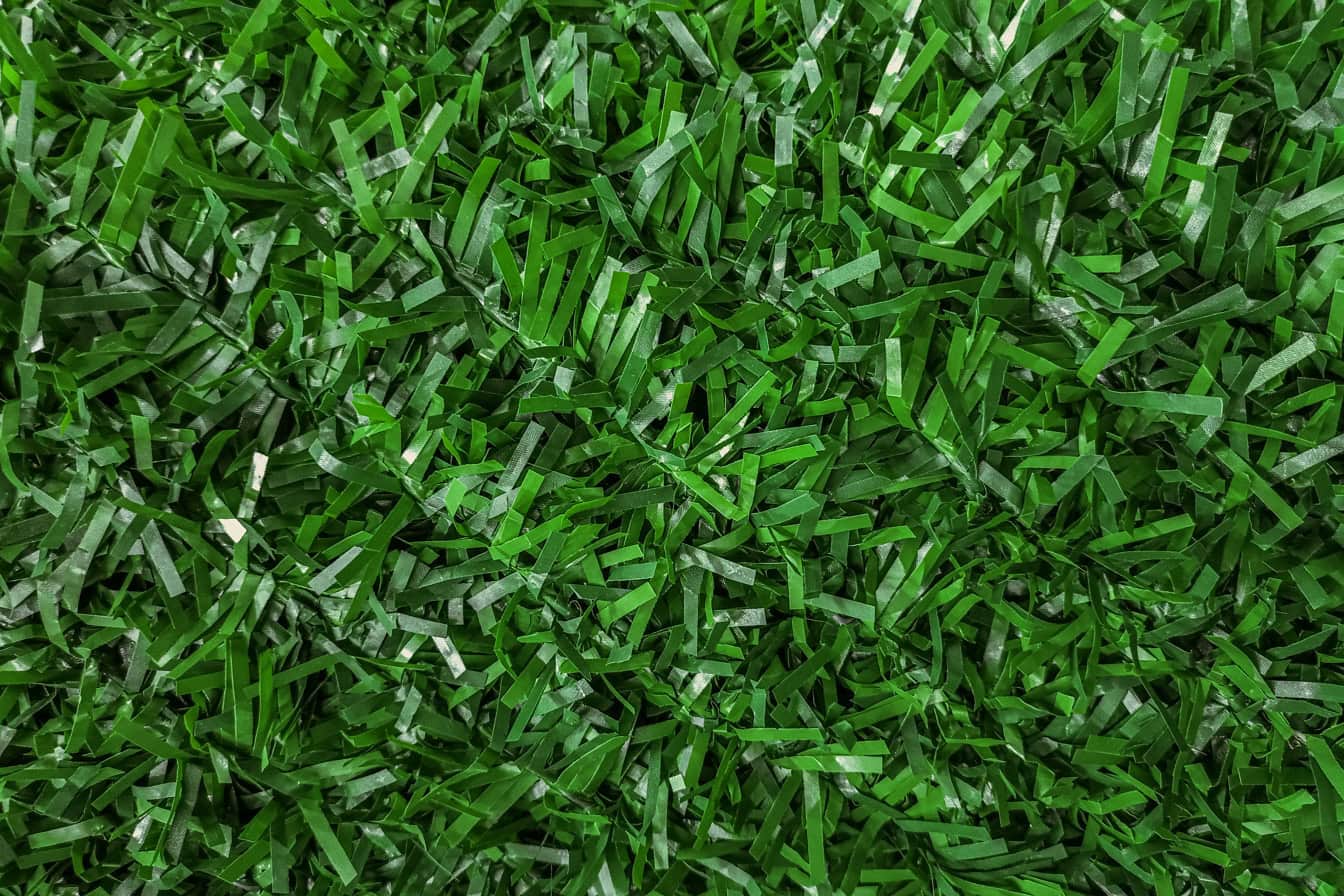 Polyvinyylikloridista, muovin synteettisestä polymeeristä, valmistetun keinotekoisen vihreän ruohon rakenne