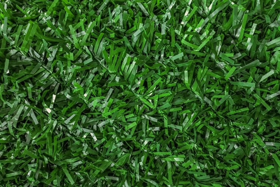 Textur eines grünen Kunstrasens aus Polyvinylchlorid, einem synthetischen Polymer aus Kunststoff