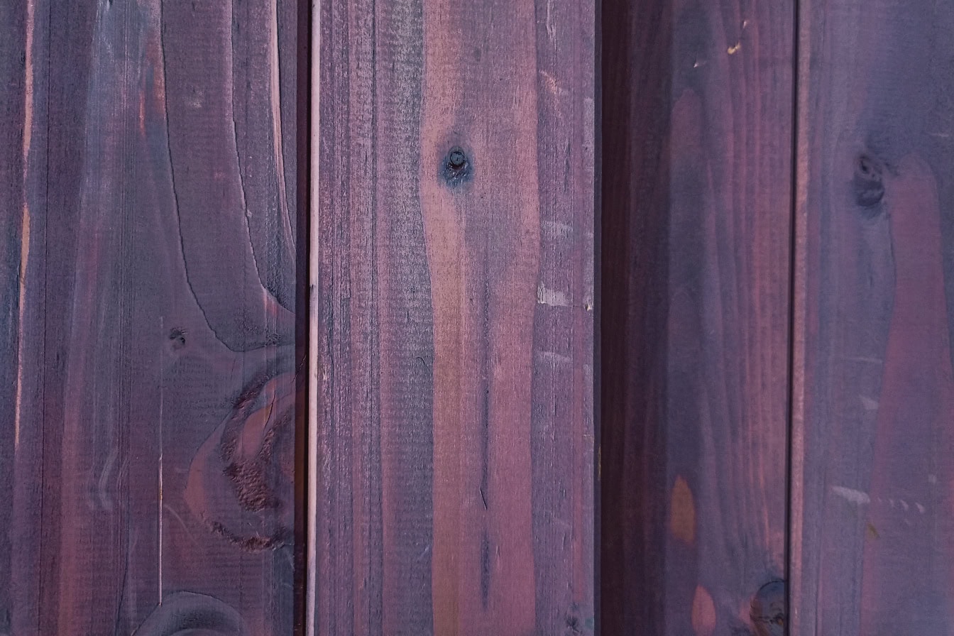 紫色に塗られた垂直に積み上げられた広葉樹の厚板