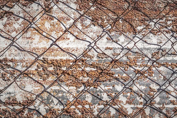 Текстурата на поцинкован метал със следи от изолационна пяна върху него с телена ограда над него