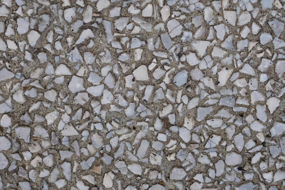 Textuur van grijsachtig witte fragmenten van granietstenen in concrete oppervlakte