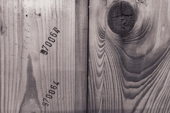 Texture di un pannello di legno con assi impilate verticalmente con nodi e segni industriali con numeri